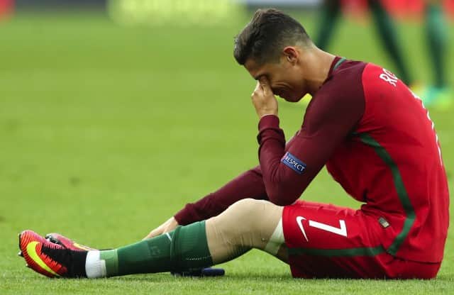 Portugal's Cristiano Ronaldo cries on the pitch during the Euro 2016 final soccer match between Portugal and France at the Stade de France in Saint-Denis, north of Paris, Sunday, July 10, 2016. (AP Photo/Thanassis Stavrakis)