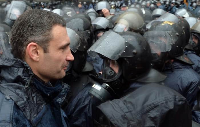 One of the leaders of the pro-European Ukrainian opposition Vitaliy Klitschko (L) faces riot police surrounding the Ukrainian Cabinet of the Ministers during a protest in Kiev on November 25, 2013. Pro-West Ukrainians staged the biggest protest rally in Kiev since the 2004 Orange Revolution, demanding that the government sign a key pact with the European Union. The opposition called the rally after President Viktor Yanukovych's government reversed a plan to sign a historic deal deepening ties with the European Union, in a U-turn critics said was forced by the Kremlin. AFP PHOTO/ SERGEI SUPINSKY