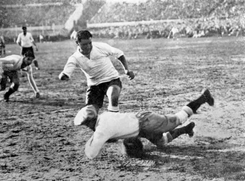 Argentina's goalkeeper Juan Botasso dives bravely at the feet of Uruguay's Hector Castro